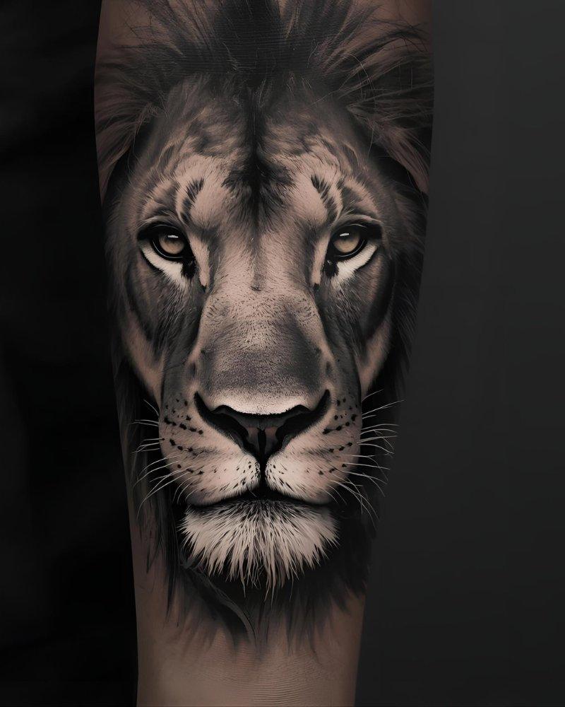 Tatuagem masculina no braço, de um leão realista.