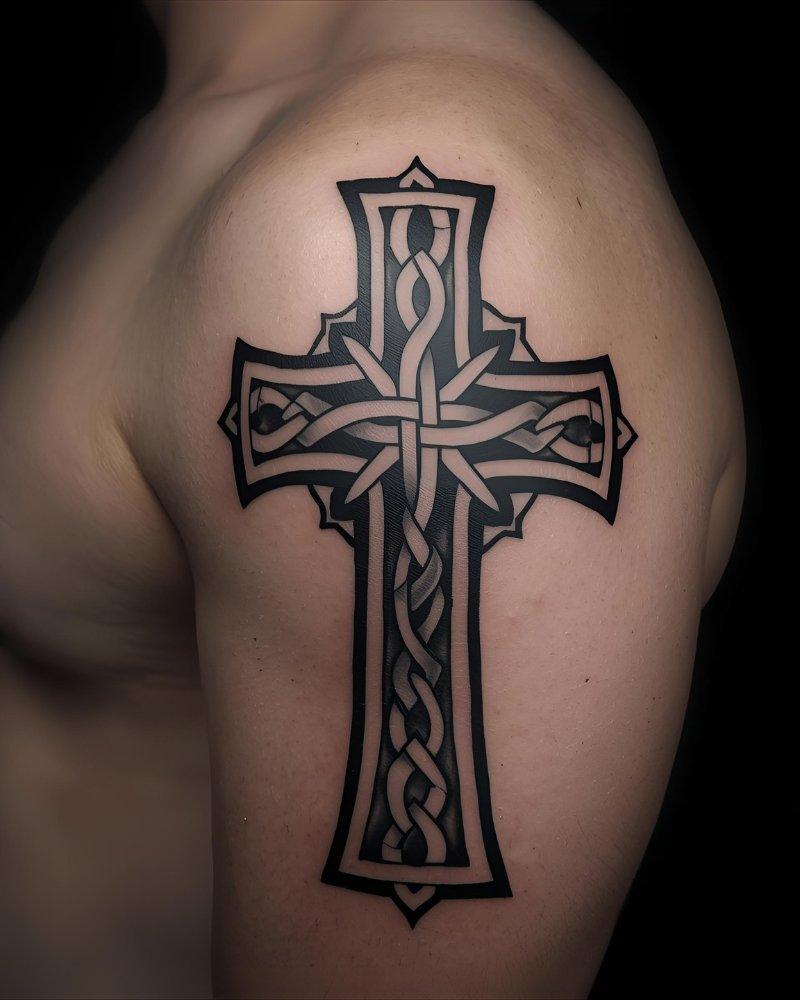 Tatuagem masculina no braço de uma cruz celta.