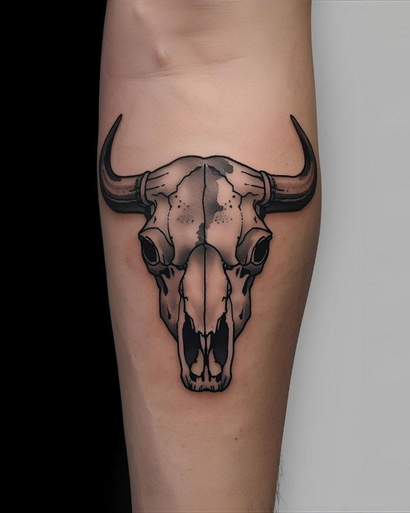 Tatuagem masculina no braço de búfalo e caveira.