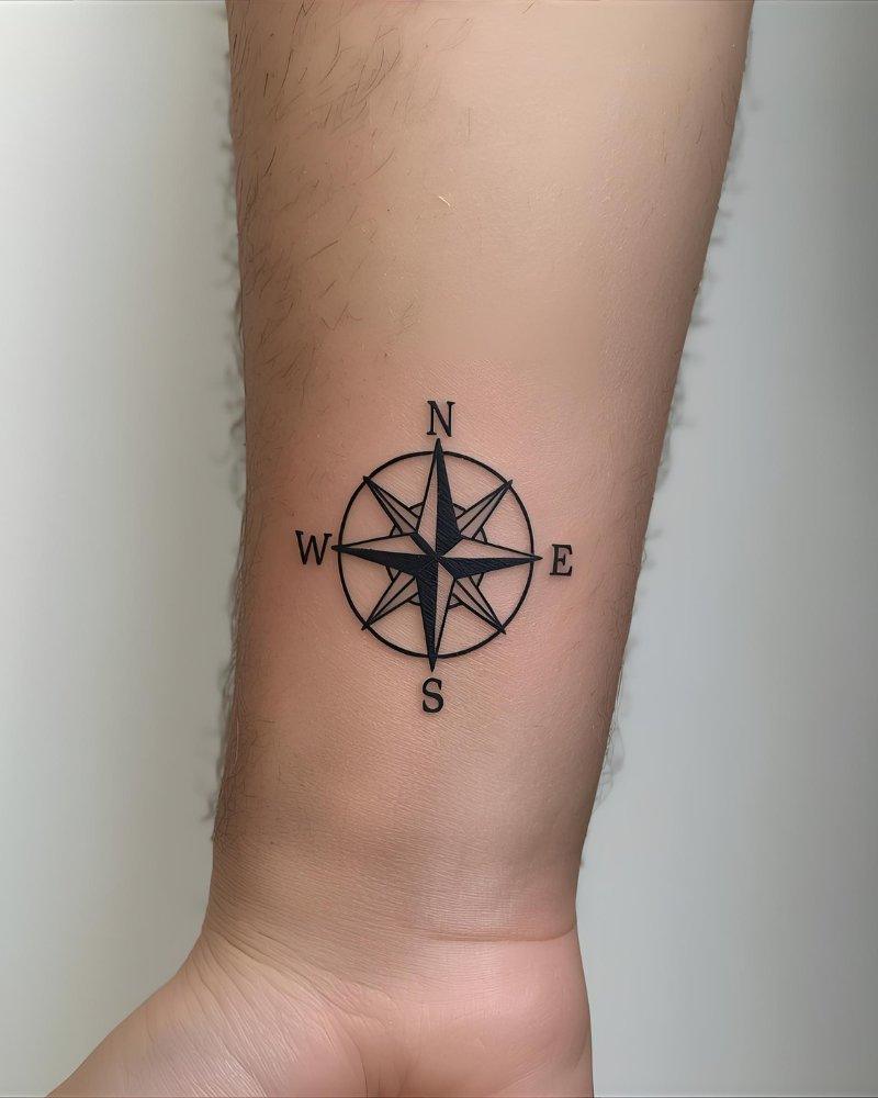 Tatuagem pequena masculina com significado de Rosa dos Ventos, simbolizando orientação.