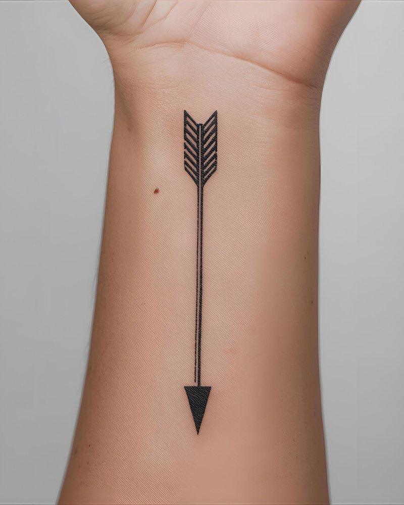 Tatuagem pequena masculina com significado de seta, simbolizando direção.